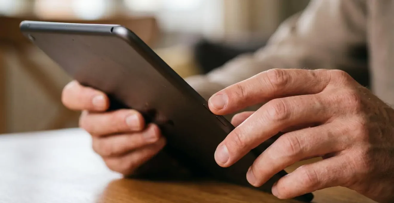 Mains d'adulte configurant les paramètres d'une tablette avec concentration et soin