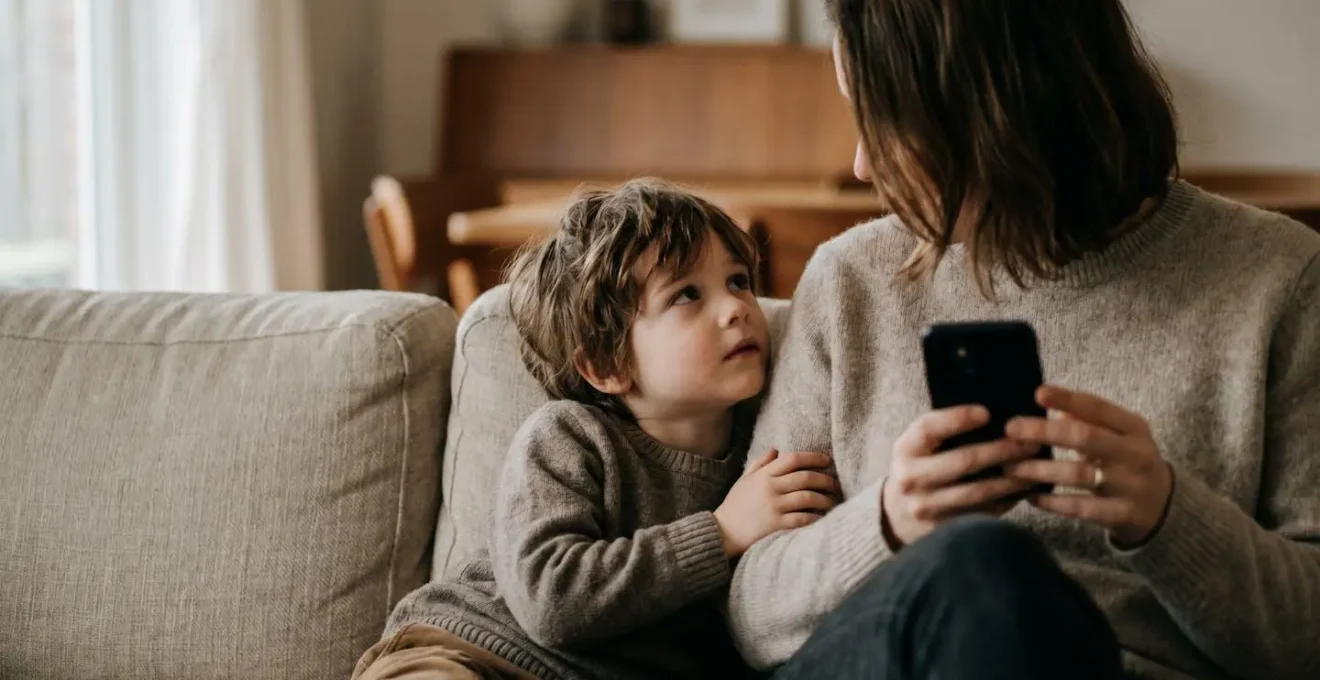 Parent et enfant ensemble mais séparés par l'usage du smartphone, symbolisant la distraction parentale numérique